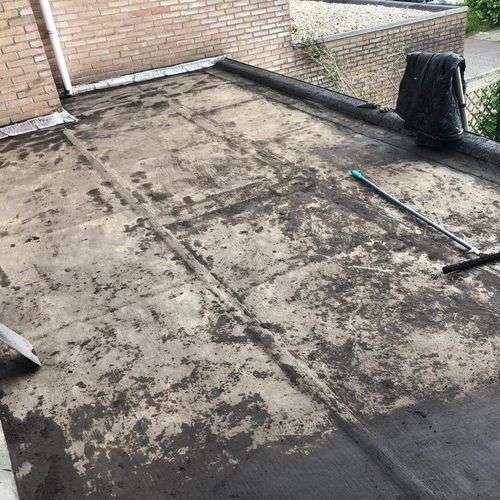 Schoonmaken van een plat dak in Harlingen